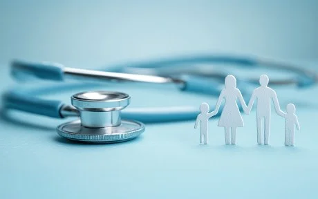 Photo: light blue background, with a stethoscope and white paper image of family standing up.
