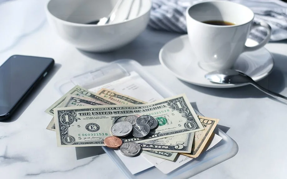 Image of a cafe receipt with U.S. money on top to pay the bill.