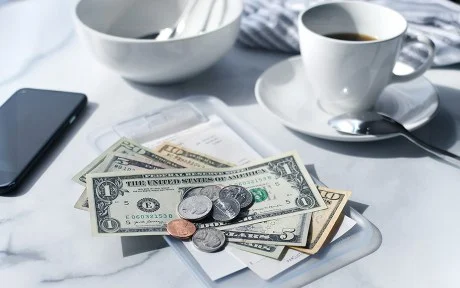 Image of a cafe receipt with U.S. money on top to pay the bill.
