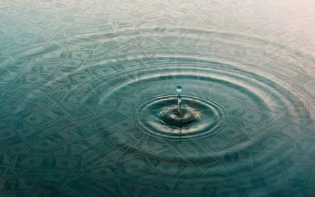 Decorative image: Ripple of water over dollar bills