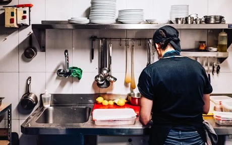 Photo: Immigrant cook working alone in a kitchen
